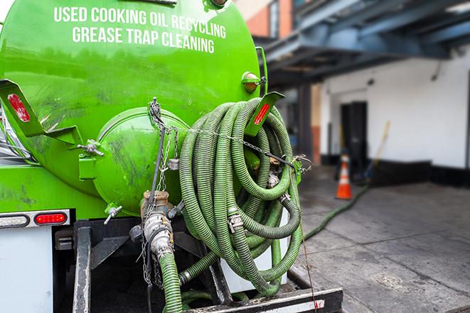 a grease trap being pumped by a sanitation technician in Bergheim, TX